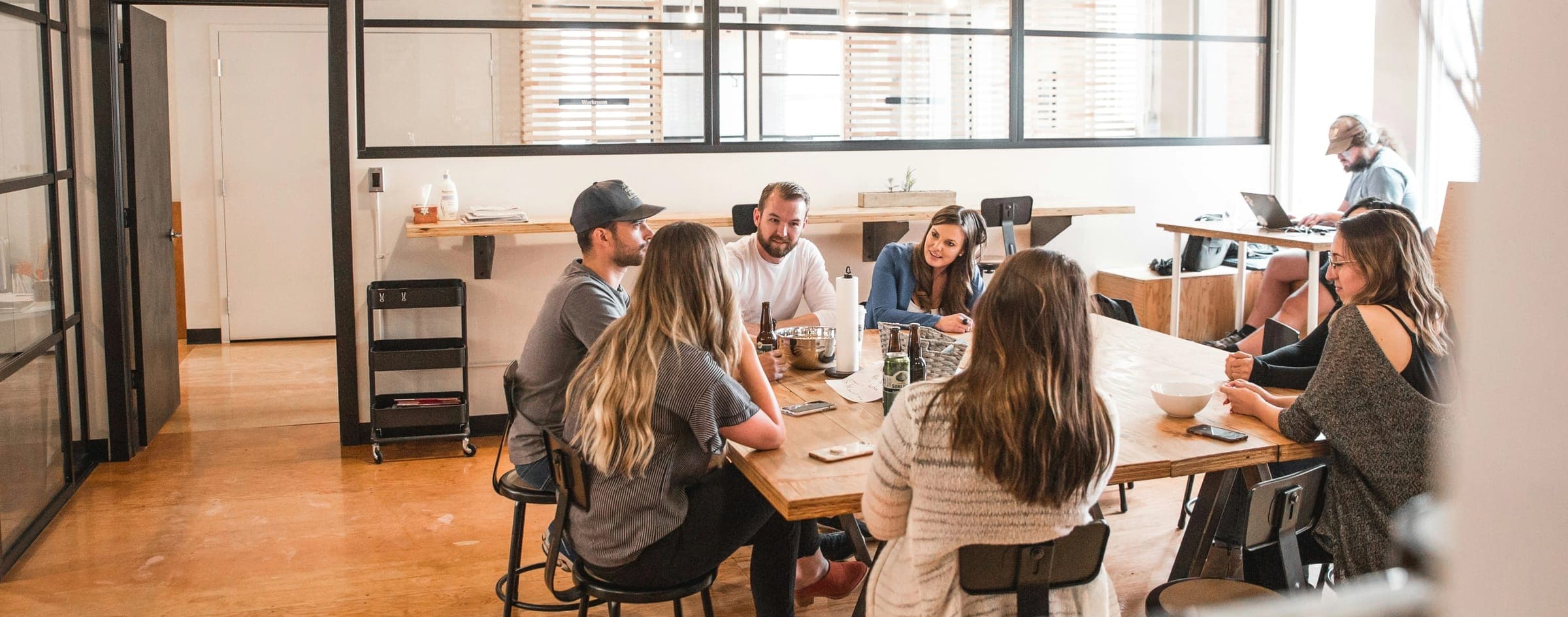 Groupe en réunion autour d’une table dans un espace de travail lumineux