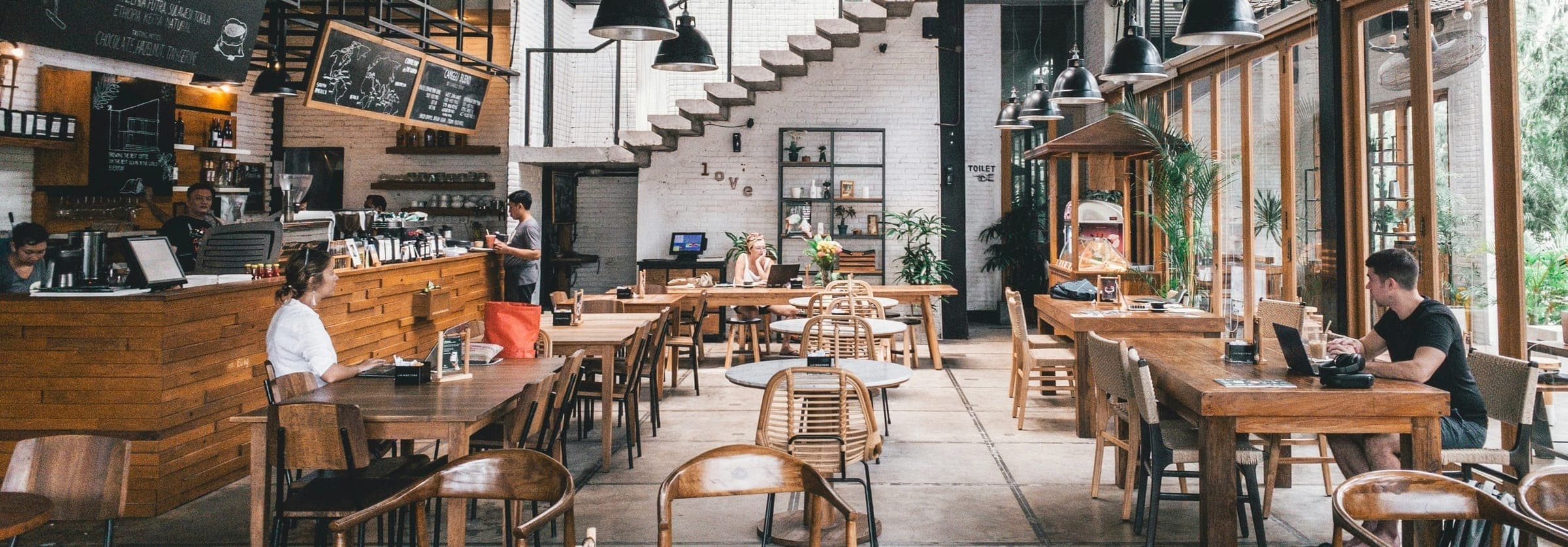 Salle de restaurant avec tables en bois et comptoir